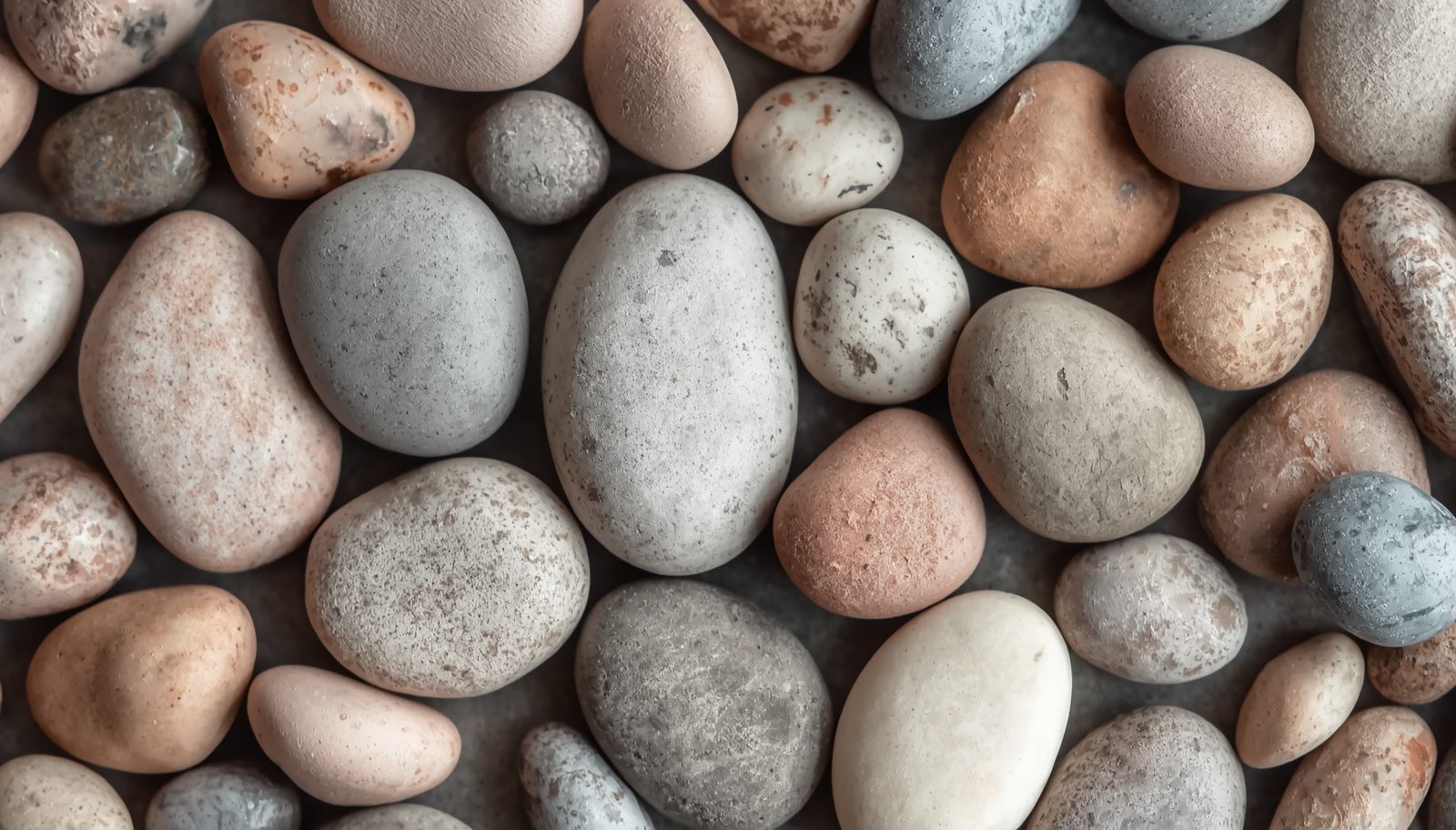 Smooth river stones in dusty rose, slate, and cream tones