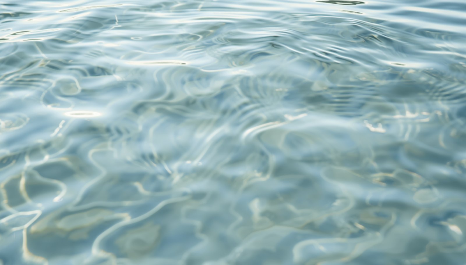Gentle, calm water ripples in soft slate-blue light